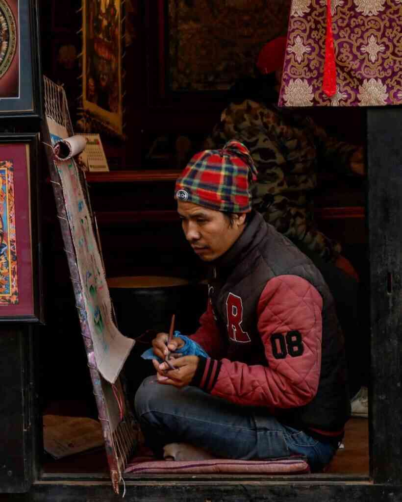 a local artisan of bhaktapur painting a mandala